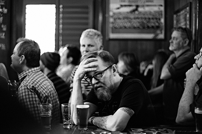 Male football fan at pub with head in hands
