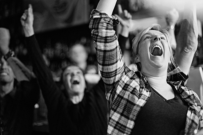 Female football fan cheering at pub